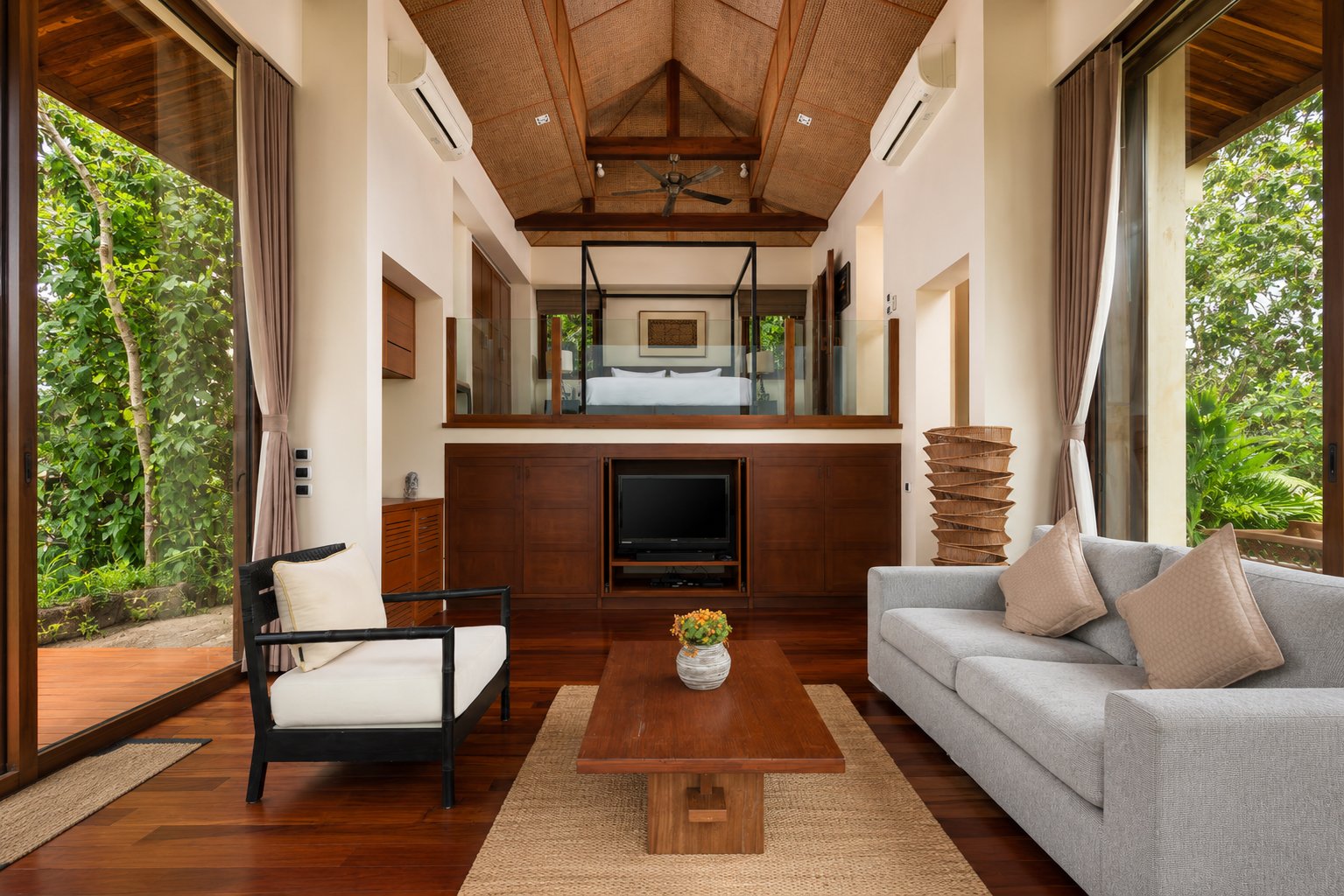 Split-level villa interior with living room below and bedroom above