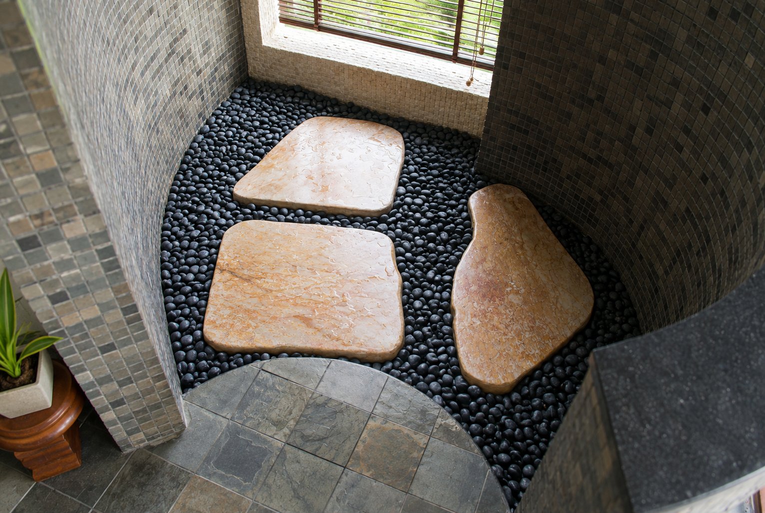 Natural stone and pebble flooring in the master villa bathroom
