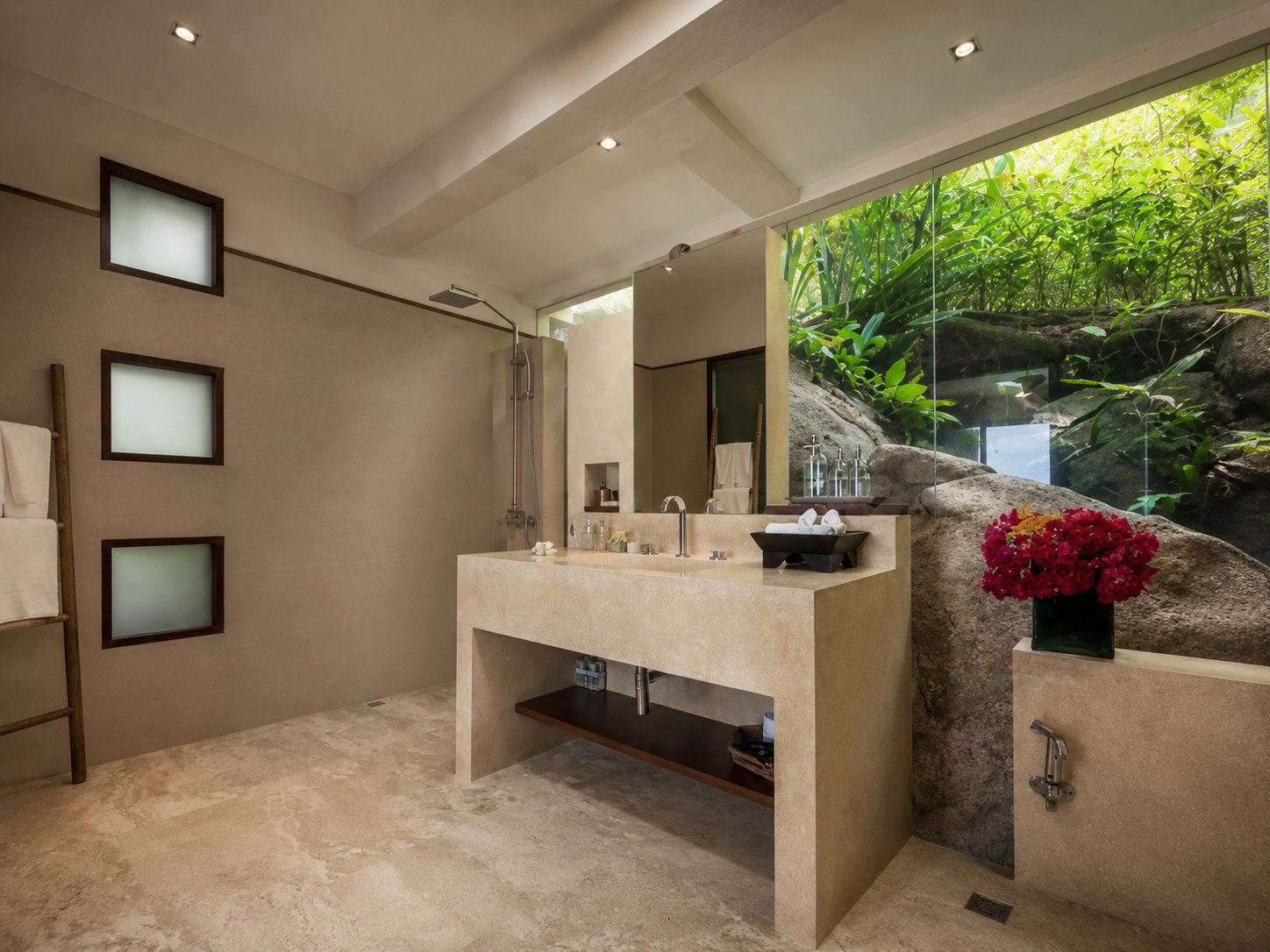 Ensuite bathroom carved into a natural boulder with jungle views