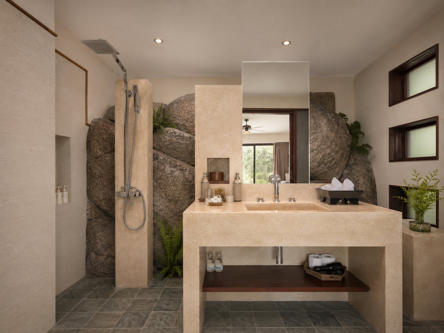 Poolside suite shower built against the natural boulder wall